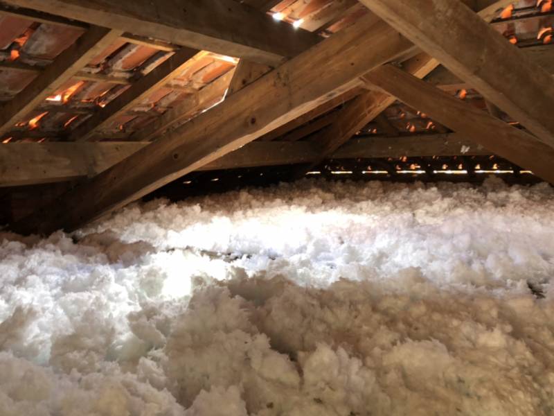 Pose d’isolation dans une charpente Comble non habiter avec laine de verre soufflée par notre entreprise de couvreur les compagnons du bâtiment